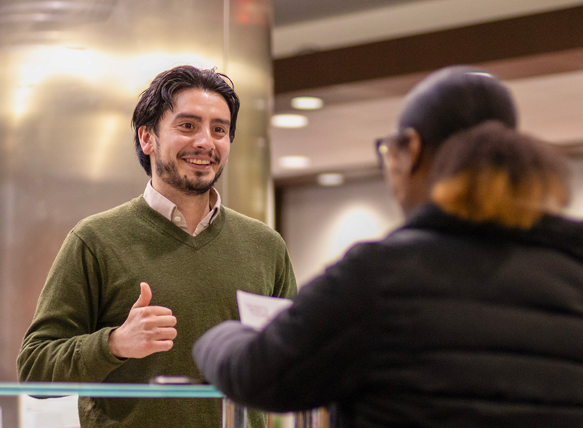 Admission counselor assisting a visitor to the enrollment services office.