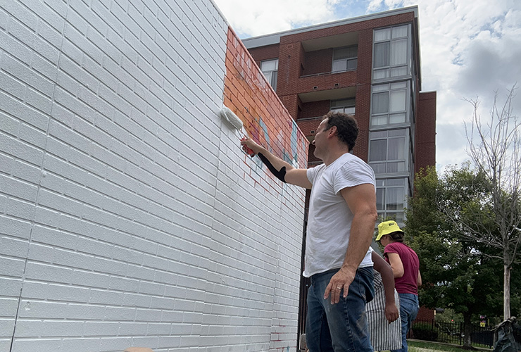 Mural being painted over in white.
