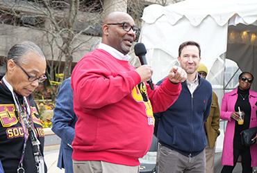 President Edington holding a microphone and speaking to UDC staff 