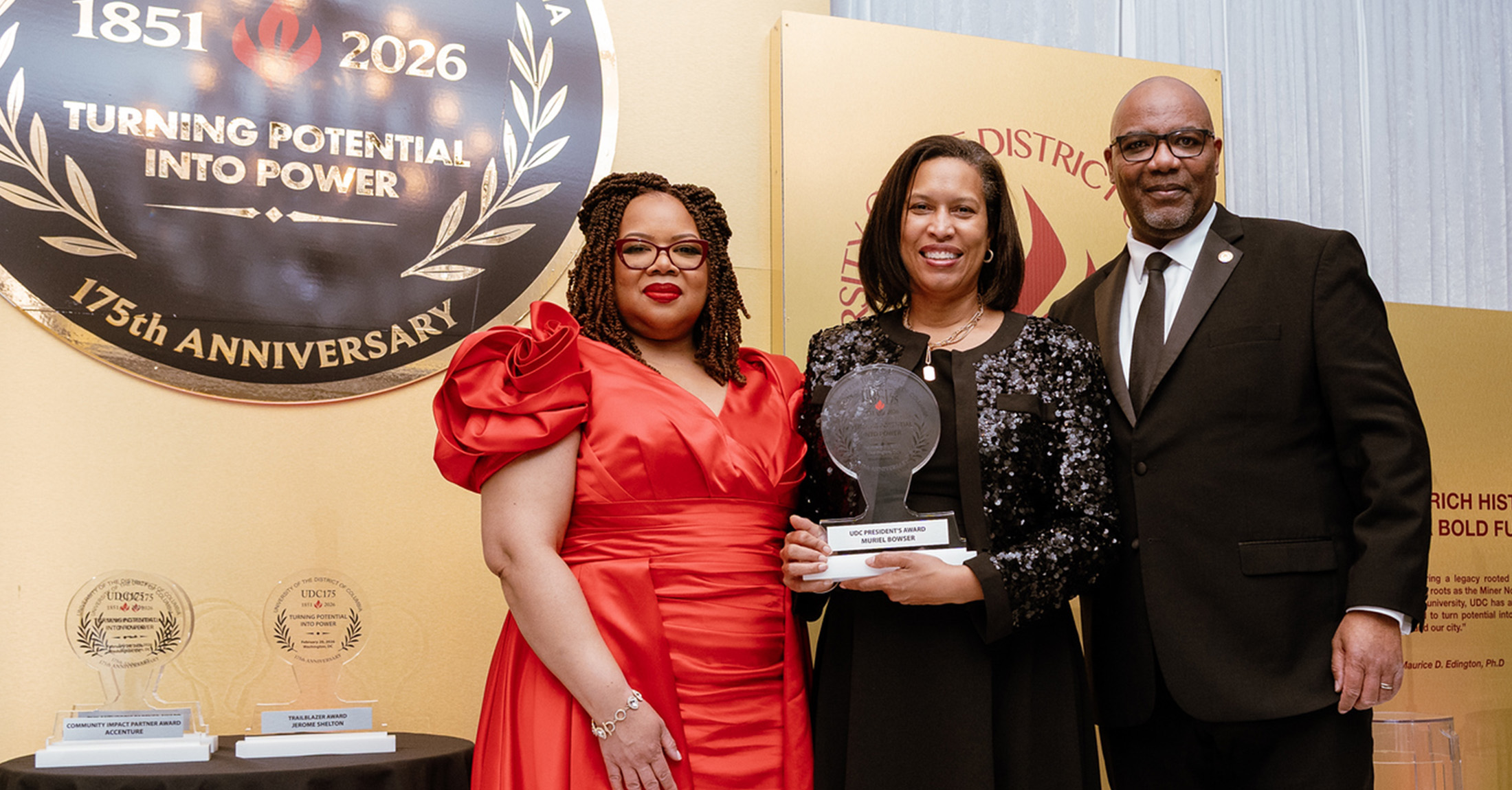 UDC President Maurice D. Edington, First Lady Tonya Barge Edington and DC Mayor Muriel Bowser standing together and smiling.