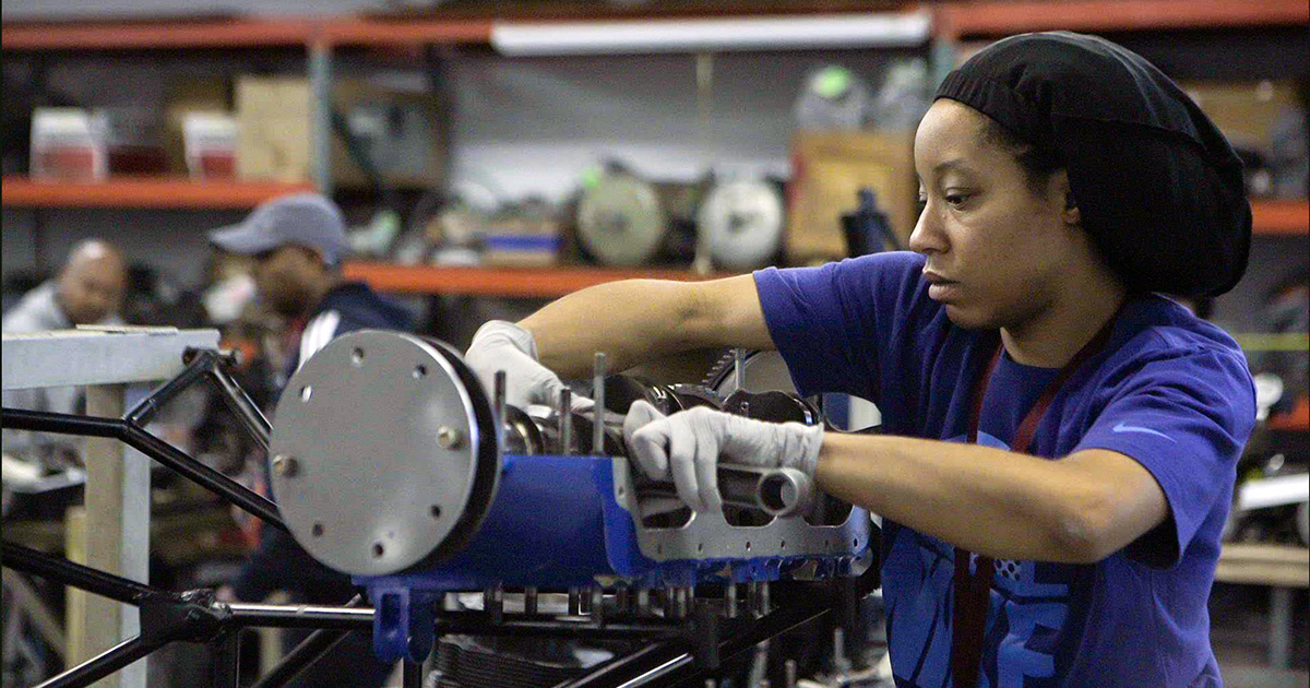 Woman working on large aviation machinery.