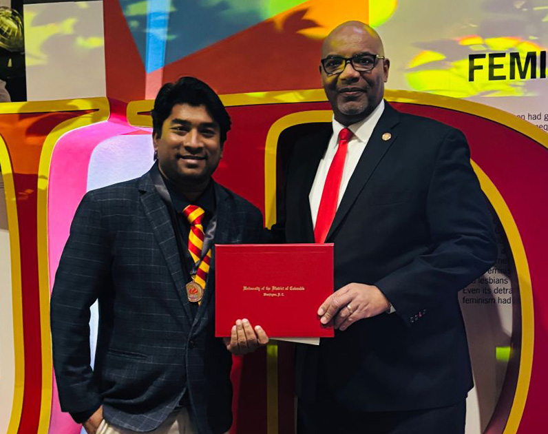 Md. Mazharul Islam and President Edington standing and holding Islam's degree certificate.