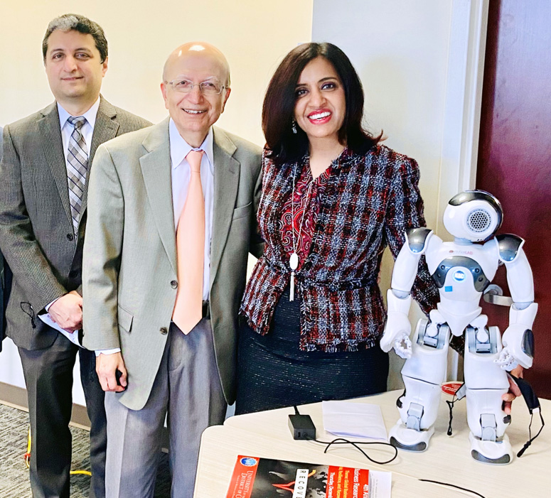 Professor Amit Arora, SBPA Dean Mohamad Sepehri and Professor Anshu Arora with a humanoid robot at UDC.