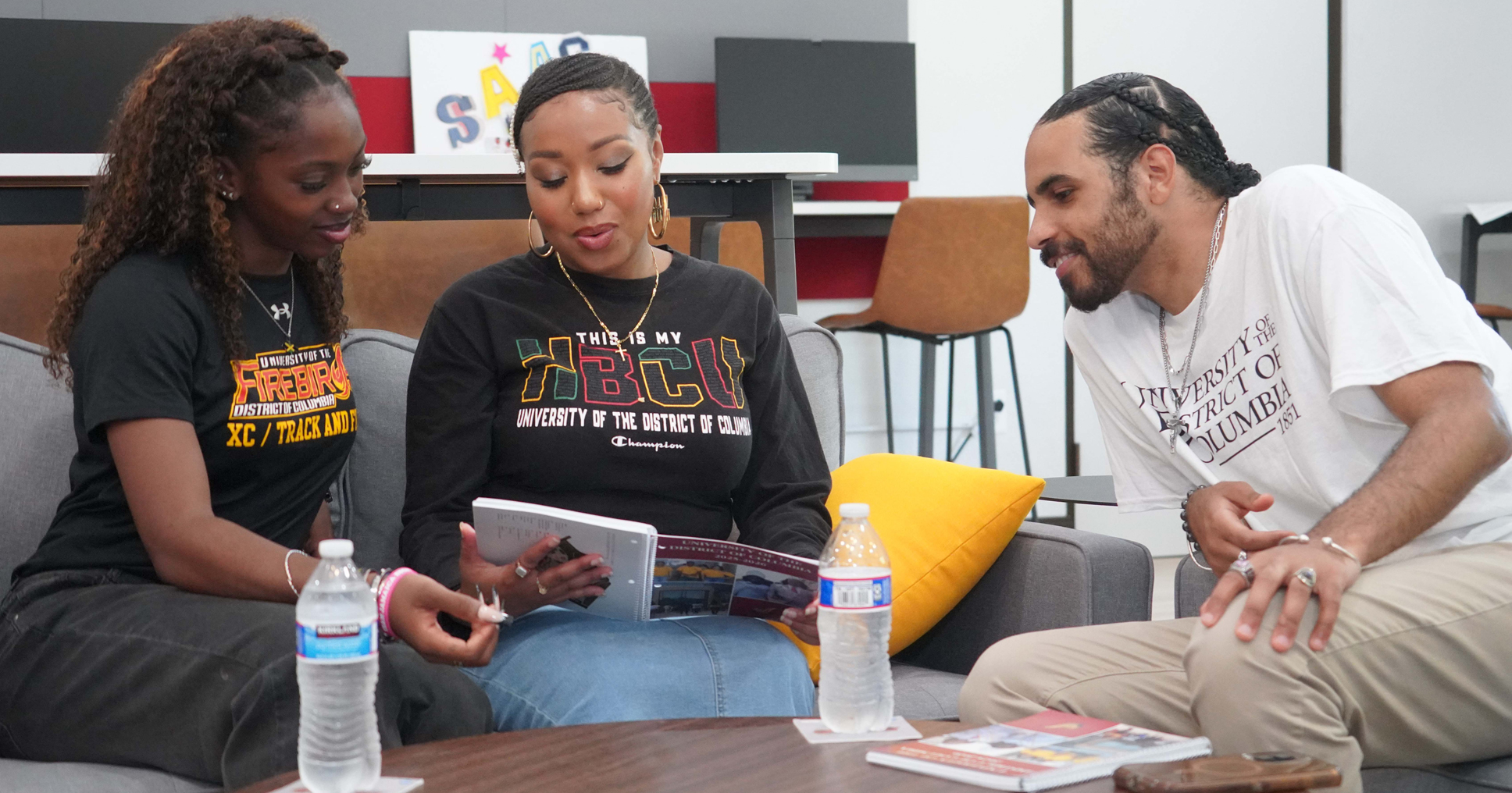 Three college students reviewing a brochure.