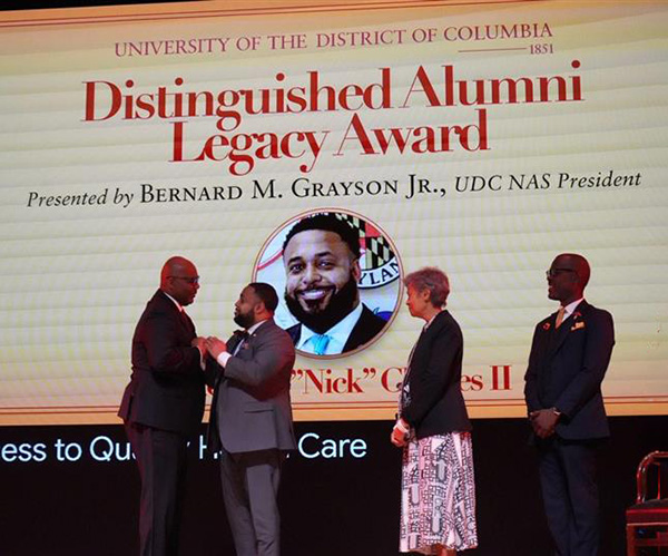 Founders Day Alumni award being presented on a stage.