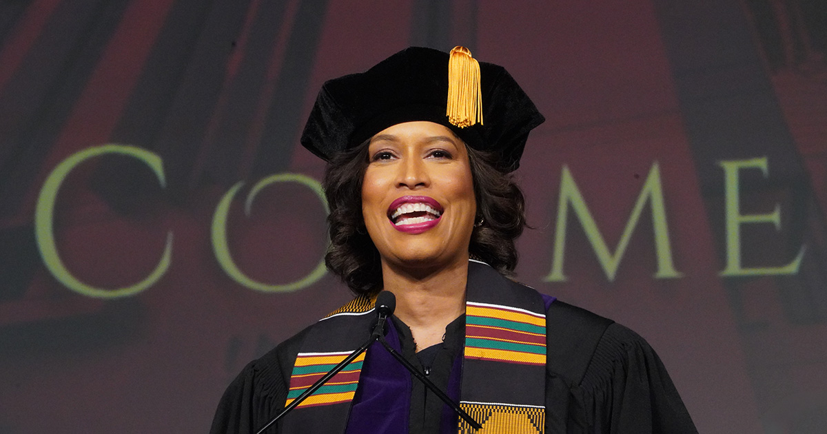 Muriel Bowser standing speaking and smiling.