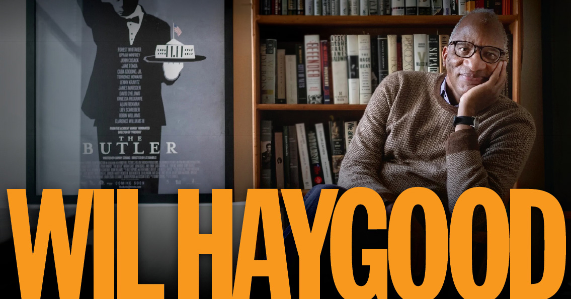 Wil Haygood sitting in a chair in front of a bookcase.