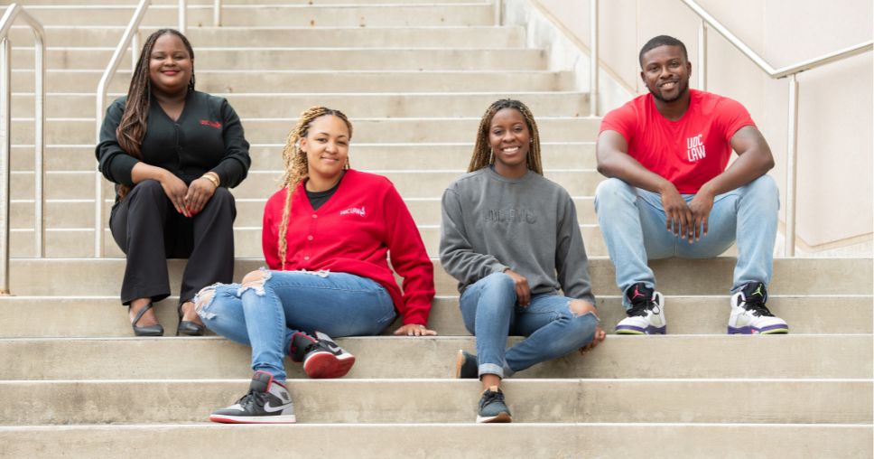 Four UDC law students sitting on steps on the Van Ness campus